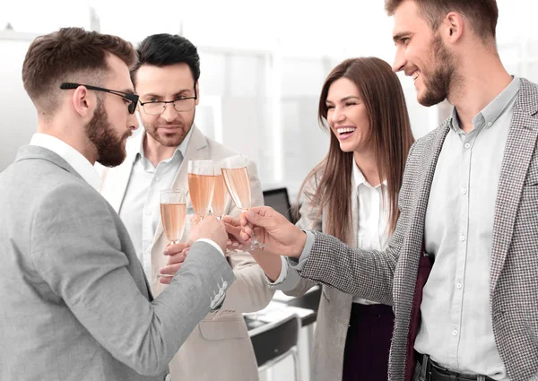 Business team verhoogt glazen champagne in het kantoor — Stockfoto