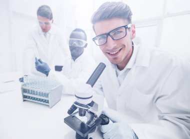 yakın up.a genç bilim adamı bir laboratuvar masada oturma kullanır. Bilim ve sağlık