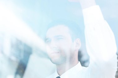 Camların arkasından manzara. Kendine güvenen iş adamı ofisinin penceresinden dışarı bakıyor.