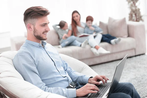 Moderne mens werkende laptop in zijn woonkamer — Stockfoto