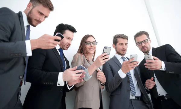 Geschäftsteam blickt auf die Bildschirme ihrer Smartphones — Stockfoto