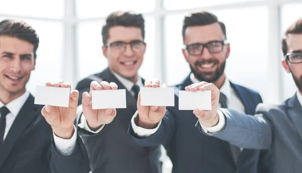 Quatre jeunes hommes d'affaires montrant leur carte de visite — Photo