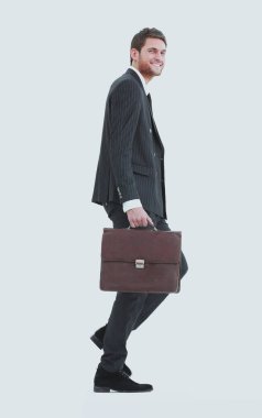 tam büyüme. bir işadamı bir deri çanta ile yürür.