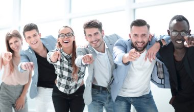 Bir grup insan kamerayı işaret ediyor ve gülümsüyor.