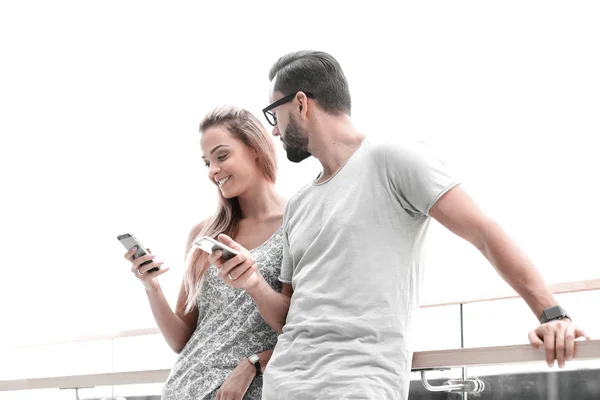 Joven pareja leyendo mensaje de texto en el teléfono inteligente — Foto de Stock