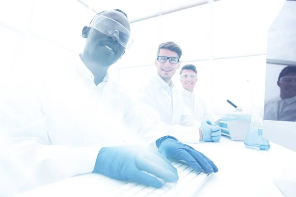 Grupo de científicos sentados en la mesa de laboratorio — Foto de Stock