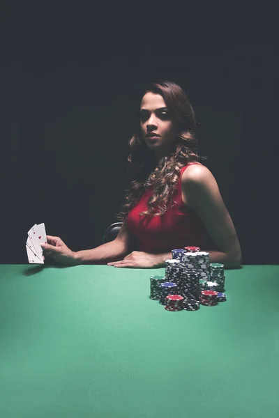 Pretty young woman gambling on green table — Stock Photo, Image