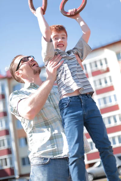 Far hjälper till sin son att komma ikapp på baren — Stockfoto