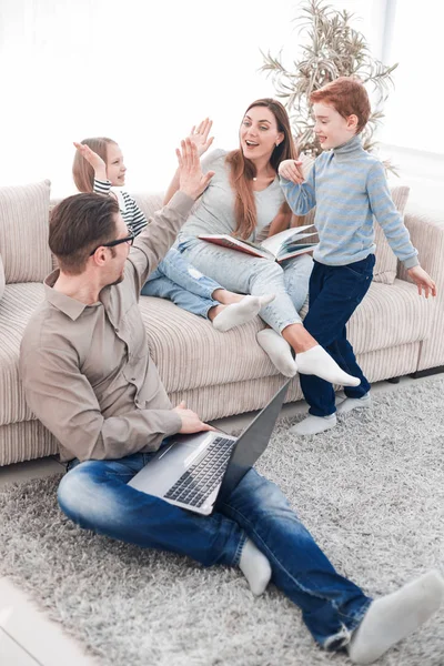 Familia alegre pasa su tiempo libre en su sala de estar — Foto de Stock