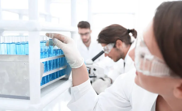 Mujer joven con tubos de ensayo en el laboratorio — Foto de Stock