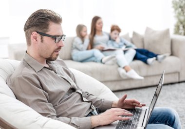 oturma odasında bir dizüstü bilgisayar kullanan başarılı adam