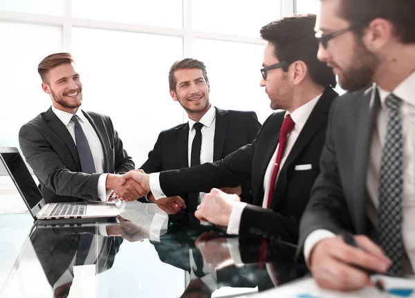 Estrechamiento de manos de los socios financieros sobre la mesa de negociación . — Foto de Stock