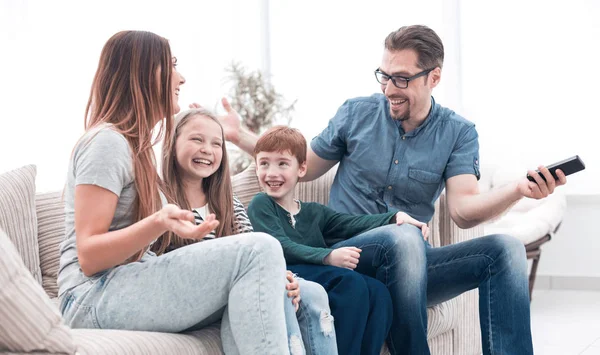 Família alegre sentado no sofá na sala de estar — Fotografia de Stock