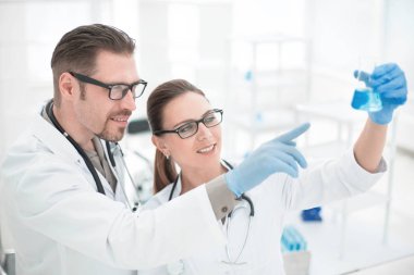 Kapatın. Araştırmacılar şişedeki sıvıyı tartışıyorlar.