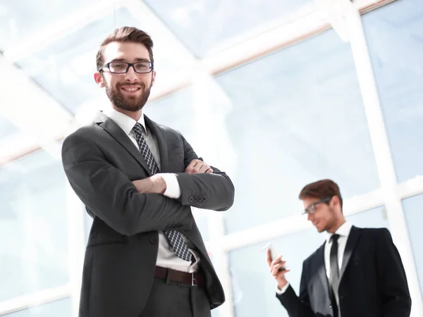 Lächelnder Geschäftsmann vor dem Hintergrund eines modernen Büros — Stockfoto