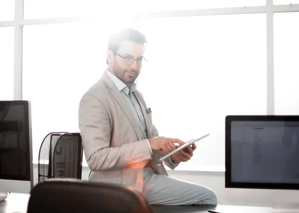 Προσεκτικός επιχειρηματίας χρησιμοποιεί μια ψηφιακή δισκίο σε ένα σύγχρονο γραφείο. — Φωτογραφία Αρχείου