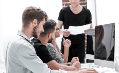 Görüntü genç başarılı işverenin işyeri bilgisayara bakarak