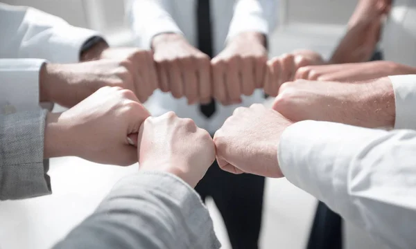 Fecha. equipe de negócios formando um círculo, fora de seus punhos — Fotografia de Stock