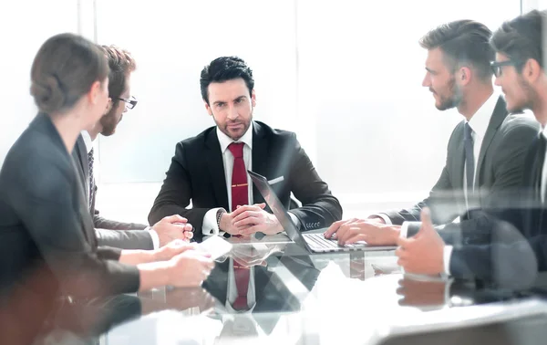 Business team discussing a new project sitting at the Desk — Stock Photo, Image