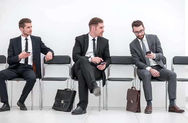 Mitarbeiter mit Smartphones auf dem Büroflur — Stockfoto