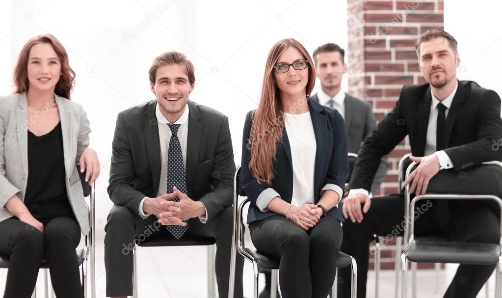 Group of attractive laughing businesspeople talking and joking sitting