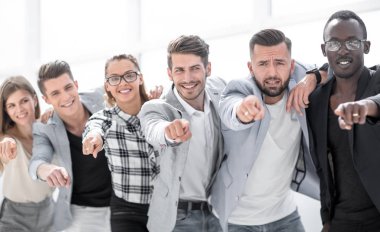 Bir grup insan kamerayı işaret ediyor ve gülümsüyor.