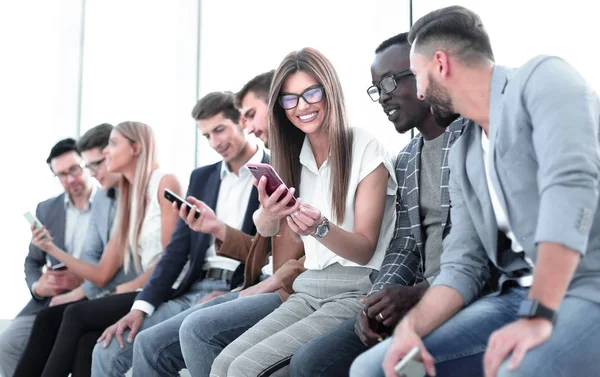 Grupo de jóvenes mirando las pantallas de sus teléfonos inteligentes — Foto de Stock