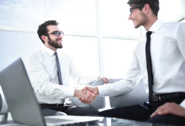 Geschäftspartner schütteln sich im Büro sitzend — Stockfoto