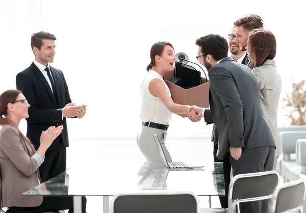 Amigable jefe da la bienvenida a nuevo empleado femenino sosteniendo una caja de cosas — Foto de Stock