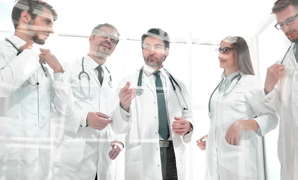 Μέσα από το γυαλί. μια ομάδα γιατρών που στέκεται στο γραφείο — Φωτογραφία Αρχείου