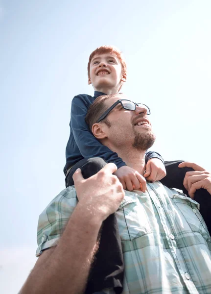 Happy son sits on his fathers shoulders — Stock Photo, Image
