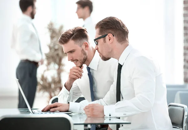 Två anställda använder en bärbar dator för att kontrollera data. — Stockfoto