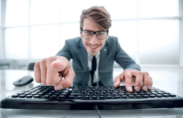 Hombre apuntando a algo con el dedo y usando el teclado de la computadora —  Fotos de Stock