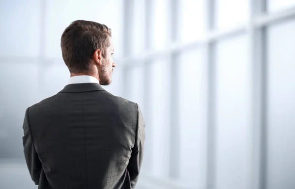 Tylny view.businessman stojący w pobliżu okna biura — Zdjęcie stockowe