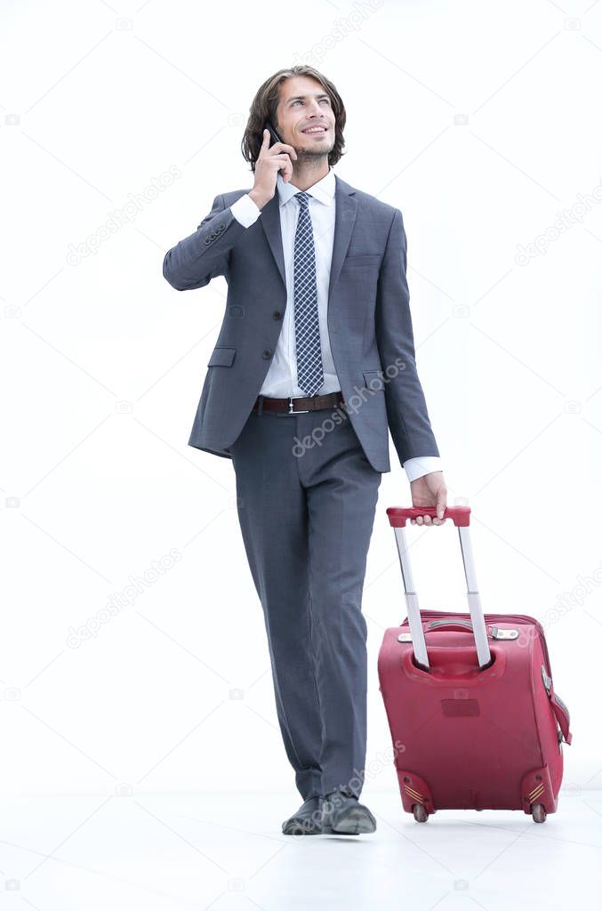 businessman with travel suitcase talking on the phone