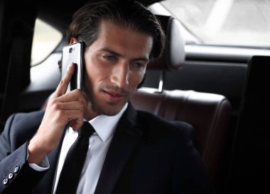 Yakışıklı işadamı cep telefonu arabaya kullaranarak.