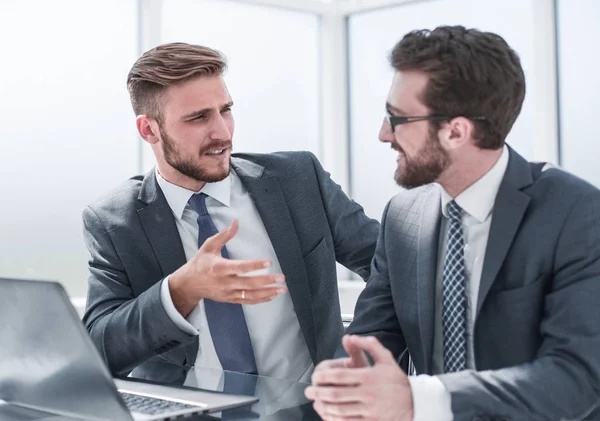 Dos hombres de negocios hablando, sentados en su escritorio —  Fotos de Stock