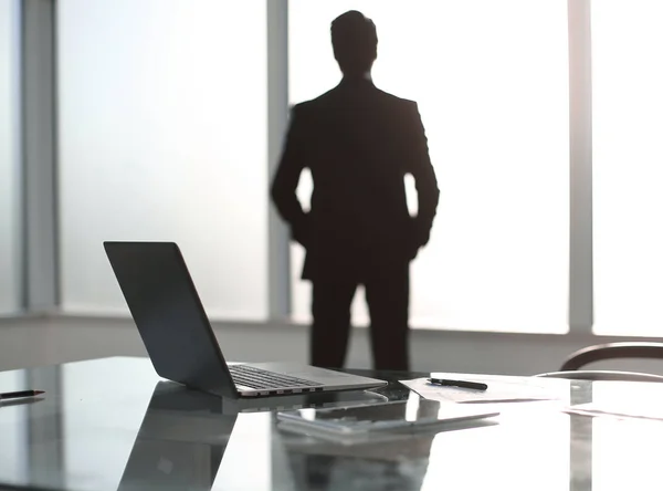 Бизнесмен стоит в современном офисе и смотрит в окно . — стоковое фото