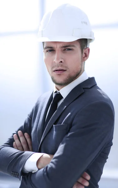 Серьезный инженер в строительном шлеме смотрит в строительную компанию — стоковое фото
