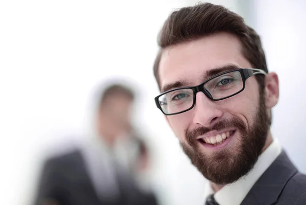 Nahaufnahme. Lächelnder Geschäftsmann im Hintergrund des Büros — Stockfoto