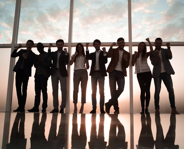 Ομάδα νέων επαγγελματιών που στέκεται σε ένα γραφείο με ένα μεγάλο παράθυρο — Φωτογραφία Αρχείου