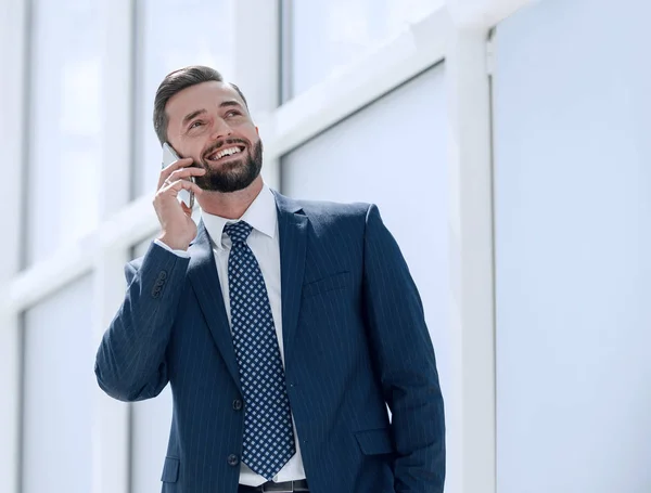 Hombre de negocios sonriente hablando en un teléfono móvil —  Fotos de Stock