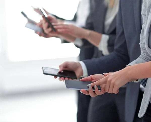 Closeup.a grupo de empleados con teléfonos inteligentes — Foto de Stock