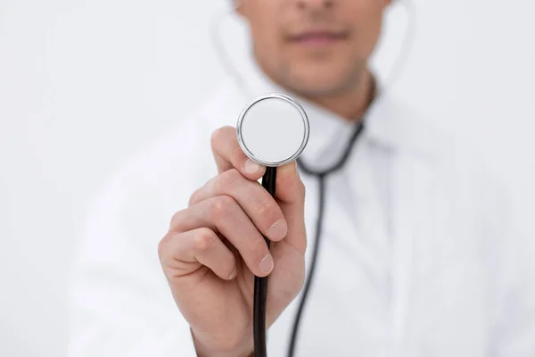 Lächelnder Arzt zeigt Stethoskop — Stockfoto