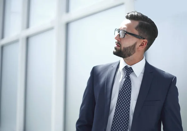 Homme d'affaires sérieux debout dans un bureau lumineux — Photo