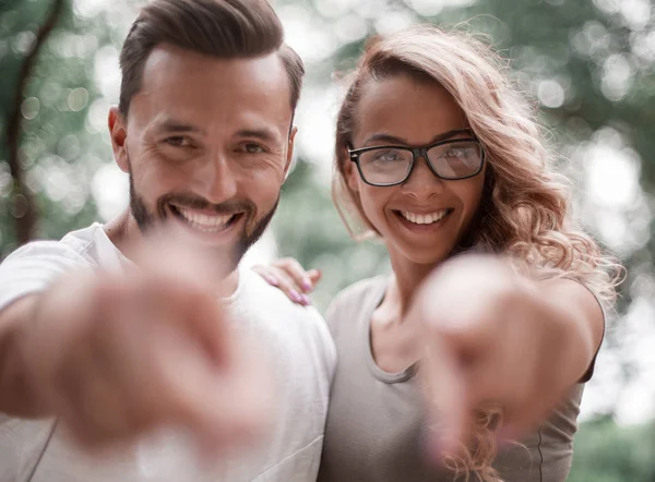 Sorridente giovane coppia che ti indica — Foto Stock