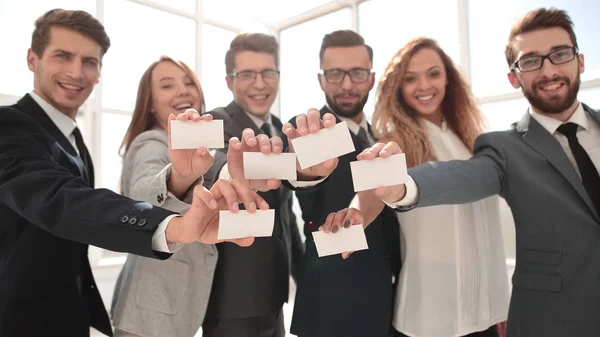 Улыбающаяся бизнес-команда, показывающая свои визитки . — стоковое фото