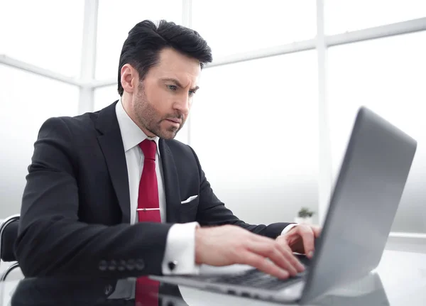 Üzletember gépel egy laptopon, ül az asztalánál — Stock Fotó