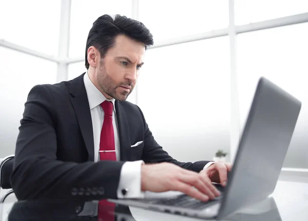 Empresario escribiendo en un portátil, sentado en su escritorio —  Fotos de Stock