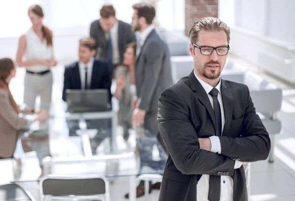 уверенный в себе бизнесмен на фоне размытого офиса
